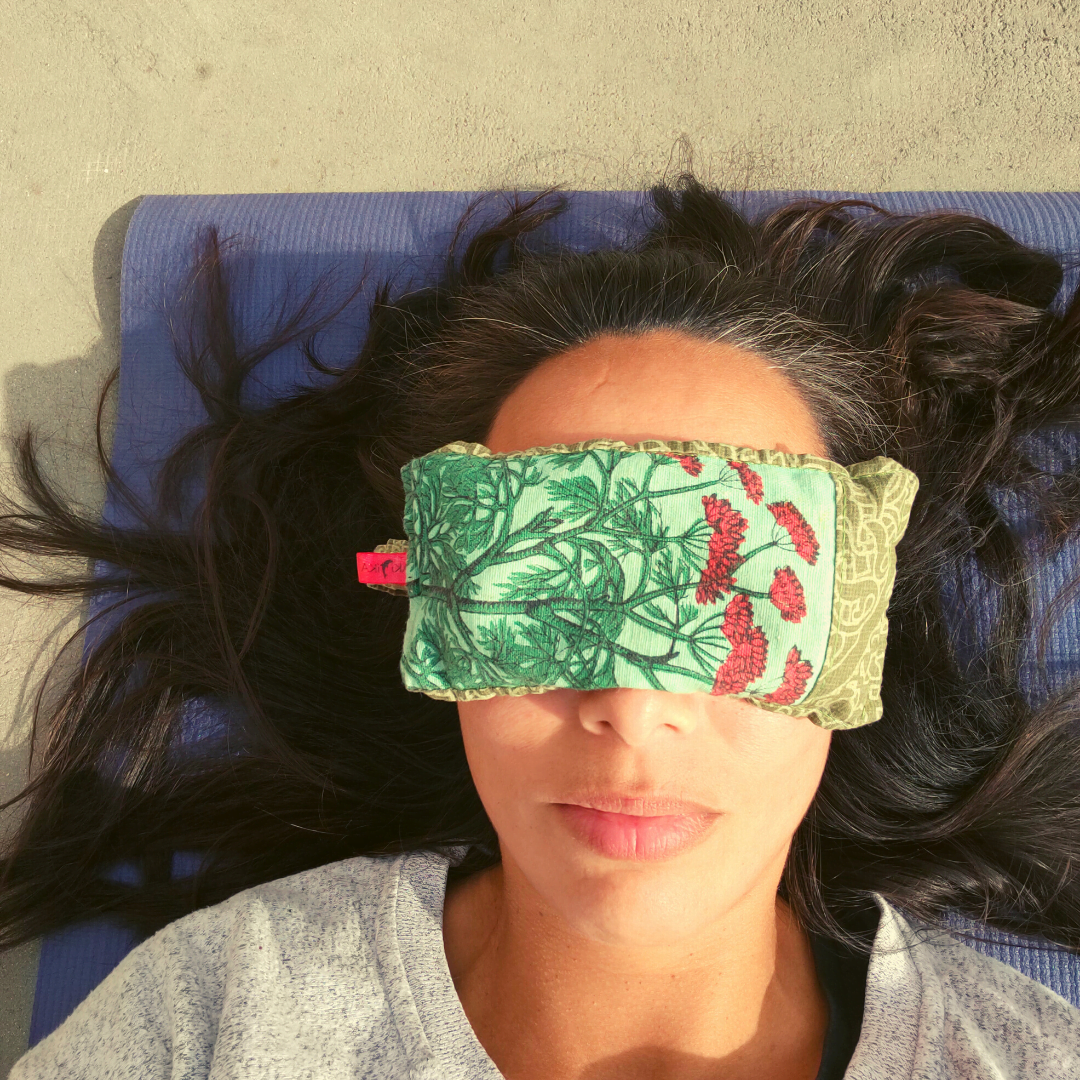 vrouw liggend op yogamat met oogmasker op voor Yoga Nidra meditatie